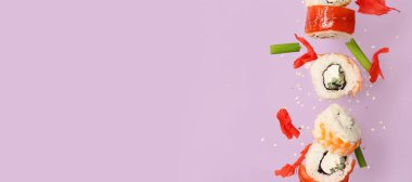 Lezzetli uçan suşi ruloları ve eflatun arkaplan üzerinde zencefil ve metin için yer var.