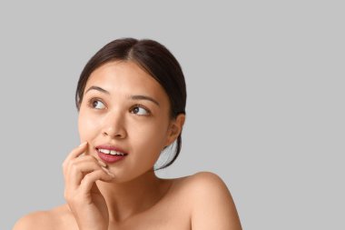 Gri arka planda güzel bir Asyalı kadın.