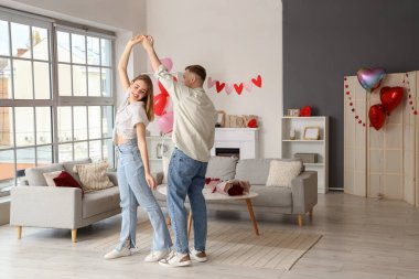 Dans eden ve sevgililer gününü evde kutlayan genç ve güzel bir çift.