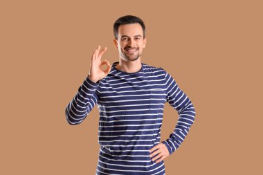 Yakışıklı adam kahverengi arka planda iyi görünüyor