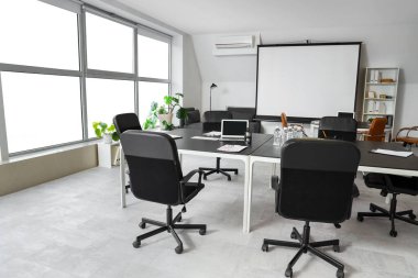 Masa, koltuk ve ekran kurulu konferans salonundaki iş toplantısı için hazırlandı.