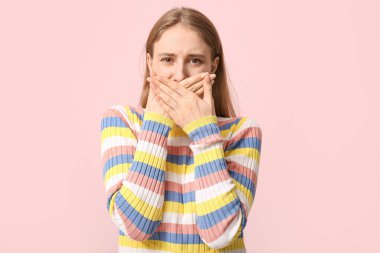 Pembe arka planda kötü kokan genç bir kadın