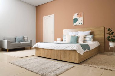 Yatak odasının içinde yatak ve kapısında yastıklar var.