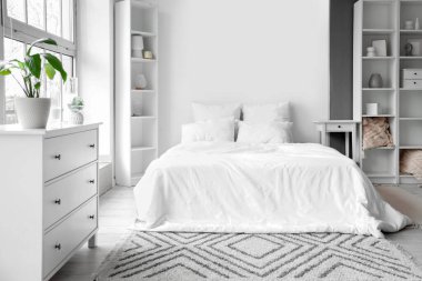 Büyük yataklı ve raf üniteli hafif yatak odasının içi.