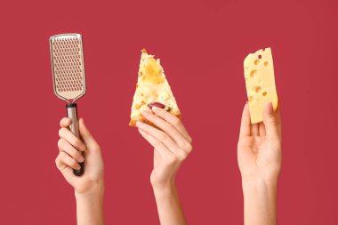 Kırmızı arka planda pizza dilimi, rende ve peynir tutan bir sürü el