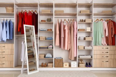 Soyunma odasında farklı kıyafetleri ve aksesuarları olan büyük gardırop.