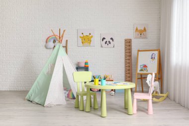 Oyun çadırı ve masası olan modern çocuk odası.