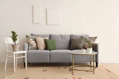 Oturma odasında yastıklı ve sehpalı rahat bir kanepe.