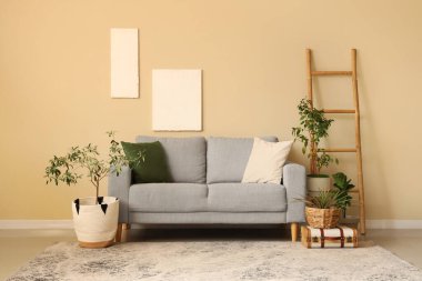 Yastıklı rahat kanepe, ev çiçekleri ve şık oturma odasında merdiven.