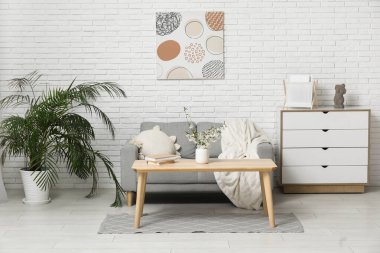 Şık oturma odasının iç tarafındaki masada çiçek açan dallar.