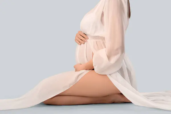 Красивая Беременная Женщина Сидит Светлом Фоне — стоковое фото