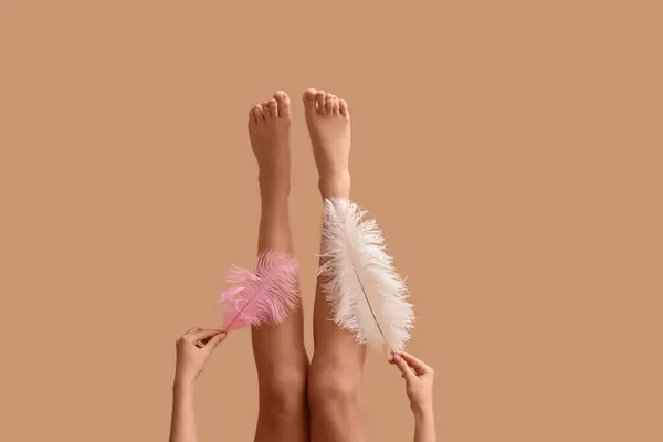 Ноги Молодой Женщины Мягкими Перьями Коричневом Фоне Концепция Эпиляции — стоковое фото