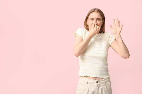 Молодая Женщина Чувствует Отвратительный Запах Розовом Фоне — стоковое фото