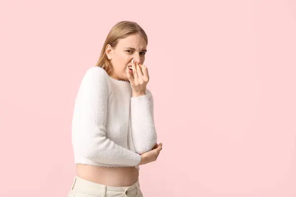 Молодая Женщина Чувствует Отвратительный Запах Розовом Фоне — стоковое фото