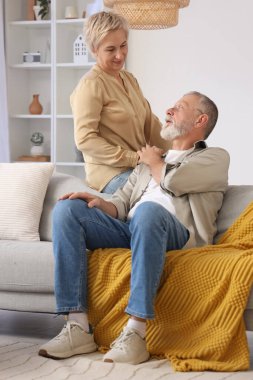 Evde el ele tutuşan olgun bir çift.