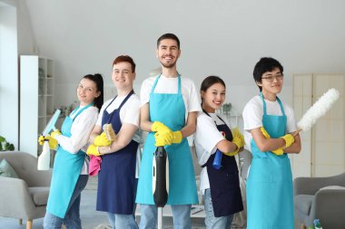 Odada temizlik malzemeleri olan bir grup genç hademe.