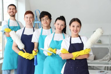 Odada temizlik malzemeleri olan bir grup genç hademe.