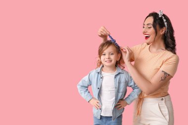 Pembe arka planda güzel bir kadın ve kızı.