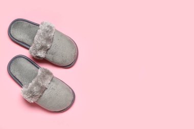 Pembe arka planda gri yumuşak terlikler. Üst görünüm