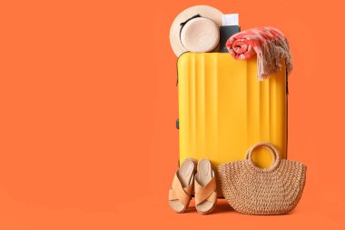 Plaj aksesuarlarıyla süslü bir bavul ve renkli bir pasaport.