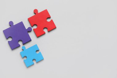 Gri arka planda renkli yapboz parçaları. Otistik bozukluk kavramı. Üst görünüm