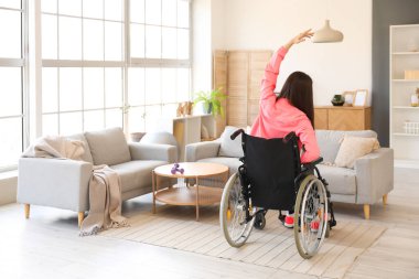 Tekerlekli sandalyede spor yapan genç bir kadın.