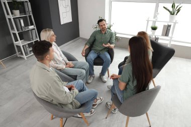 Grup terapisinde konuşan yakışıklı adam.