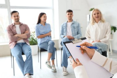 Grup terapi seansında panoya yazı yazan kadın psikolog.