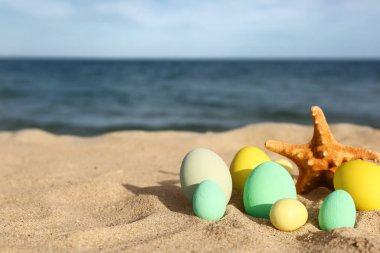 Deniz yıldızı ve bayram boyalı Paskalya yumurtaları deniz sahilinde