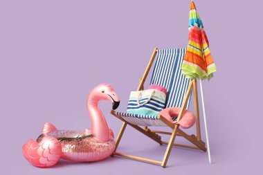 Renkli şemsiyeli çizgili güverte sandalyesi ve eflatun arka planda şişme yüzük.