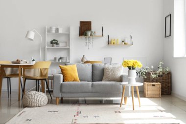 Oturma odasındaki sehpanın üzerinde nergis çiçekleri olan vazo.