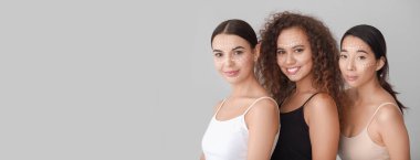 Yüzünde işaretler olan güzel genç kadınlar. Arka planda ışık ve mesaj için yer var. Kozmetoloji kavramı