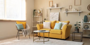 Sarı kanepesi, koltuğu ve kahve masası olan şık bir oturma odası.