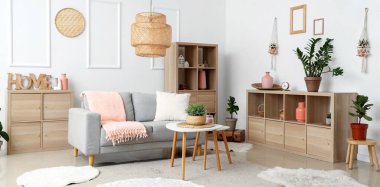 Ahşap mobilyalar ve ev bitkileriyle aydınlık oturma odasının içi