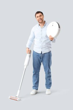 Elektrik süpürgesi olan yakışıklı bir adam.