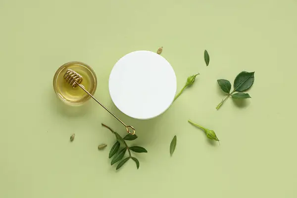 Glas Natürliche Gesichtscreme Und Honig Auf Grünem Hintergrund lizenzfreie Stockfotos