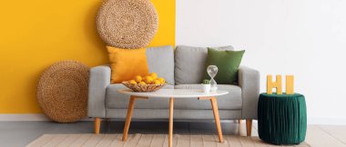 Oturma odasında masa ve puf olan rahat bir kanepe.