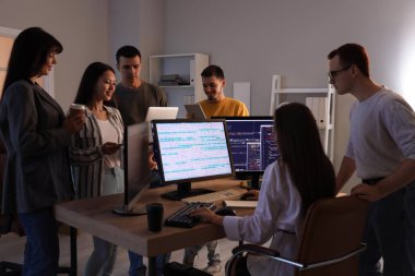 Akşam ofiste çalışan genç programcılardan oluşan bir ekip.