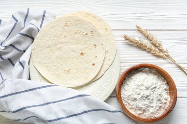 Hafif ahşap zemin üzerinde ince lavaş, un ve havlu kompozisyonu