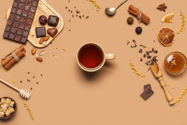 Bir fincan siyah çay ve kahverengi arka planda farklı tatlılar.