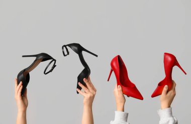 Gri arka planda farklı stil yüksek topuklu kadın elleri