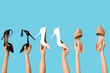 Mavi arka planda farklı stil yüksek topuklu kadın elleri