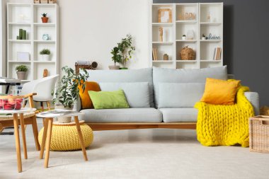 Gri kanepeli ve raf üniteli oturma odasının içi.