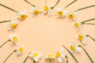 Turuncu arka planda güzel nergis çiçeklerinden yapılmış çerçeve