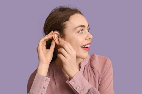 Красивая молодая женщина со слуховым аппаратом на фоне сирени