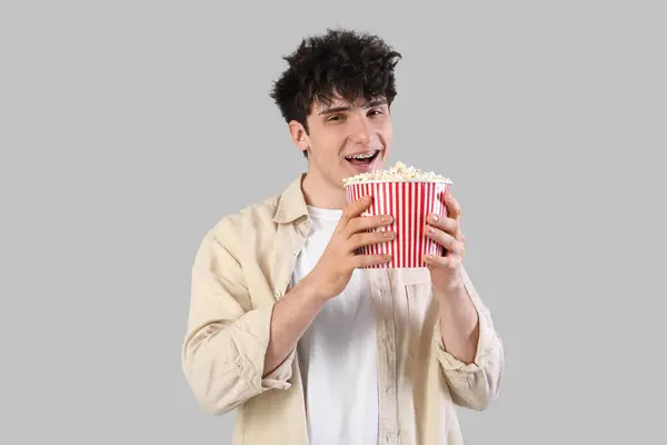 Young Man Eating Popcorn Grey Background Imagen de archivo
