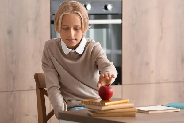 Little Boy Taking Apple While Doing Homework Kitchen Imágenes de stock libres de derechos