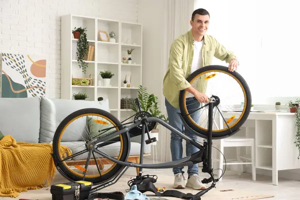 Junger Mann Repariert Fahrrad Hause Stockfoto