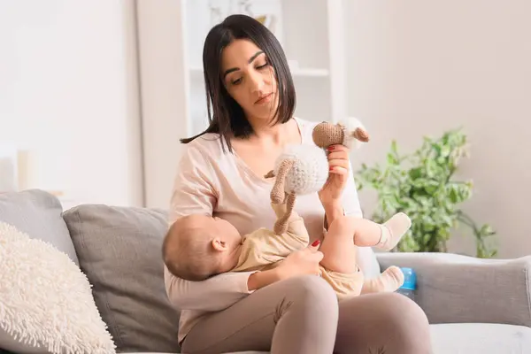 Junge Frau Mit Spielzeug Und Ihrem Postnataler Depression Leidenden Baby Stockbild
