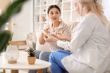 Kadın doktor evde hastaya göz damlası atıyor.